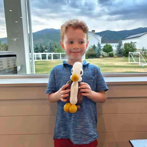 Boy holding a balloon eagle character