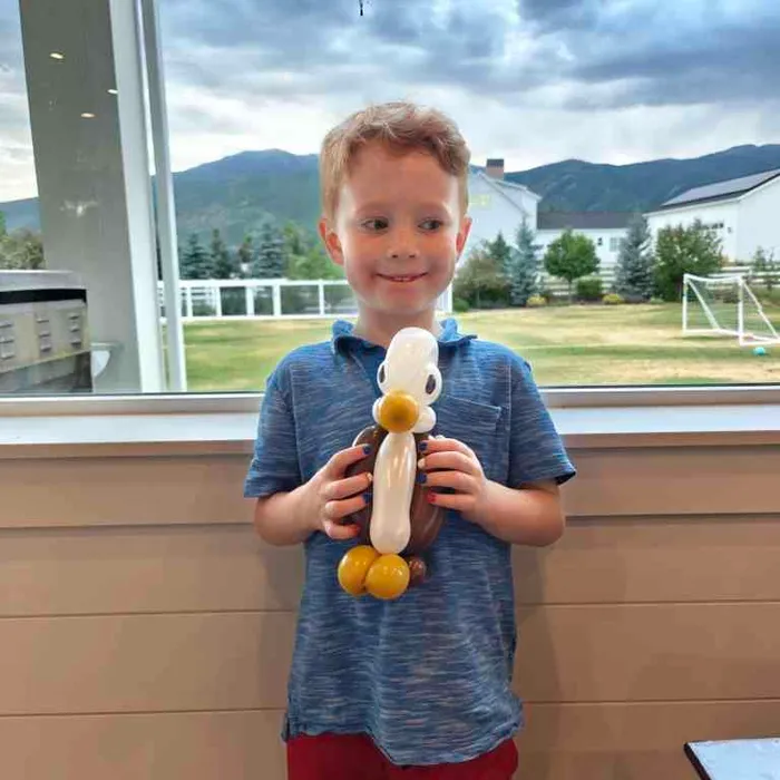 Boy holding a balloon eagle character