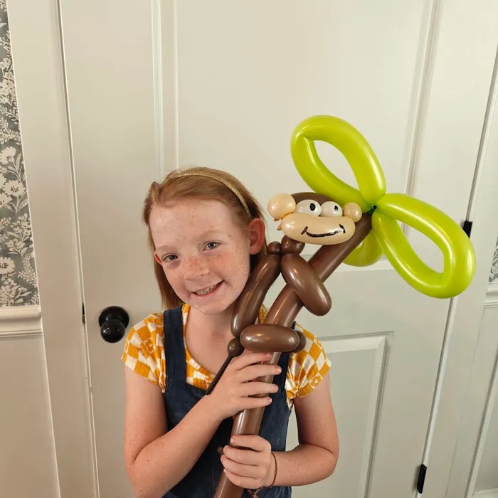Girl holding a balloon monkey character