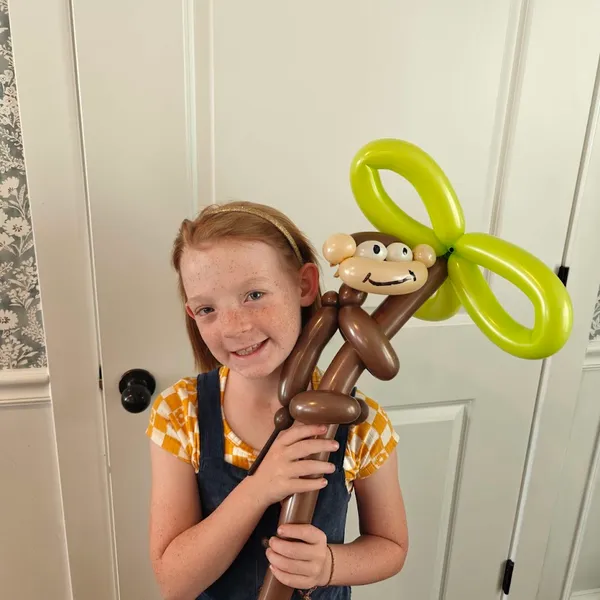 Girl holding a balloon monkey character
