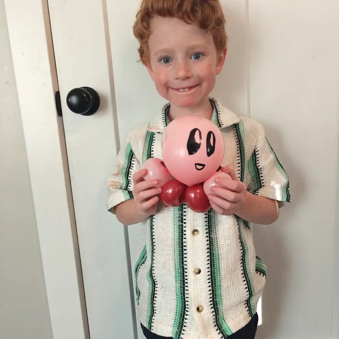 Boy holding a pink balloon video game character